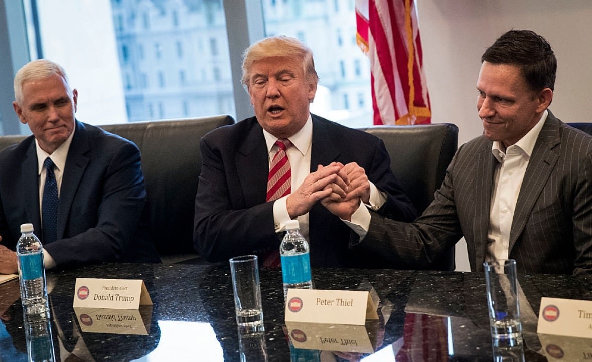 629843762 In this 2016 picture: (L to R) Vice President-elect Mike Pence looks on as President-elect Donald Trump shakes the hand of Peter Thiel during a meeting