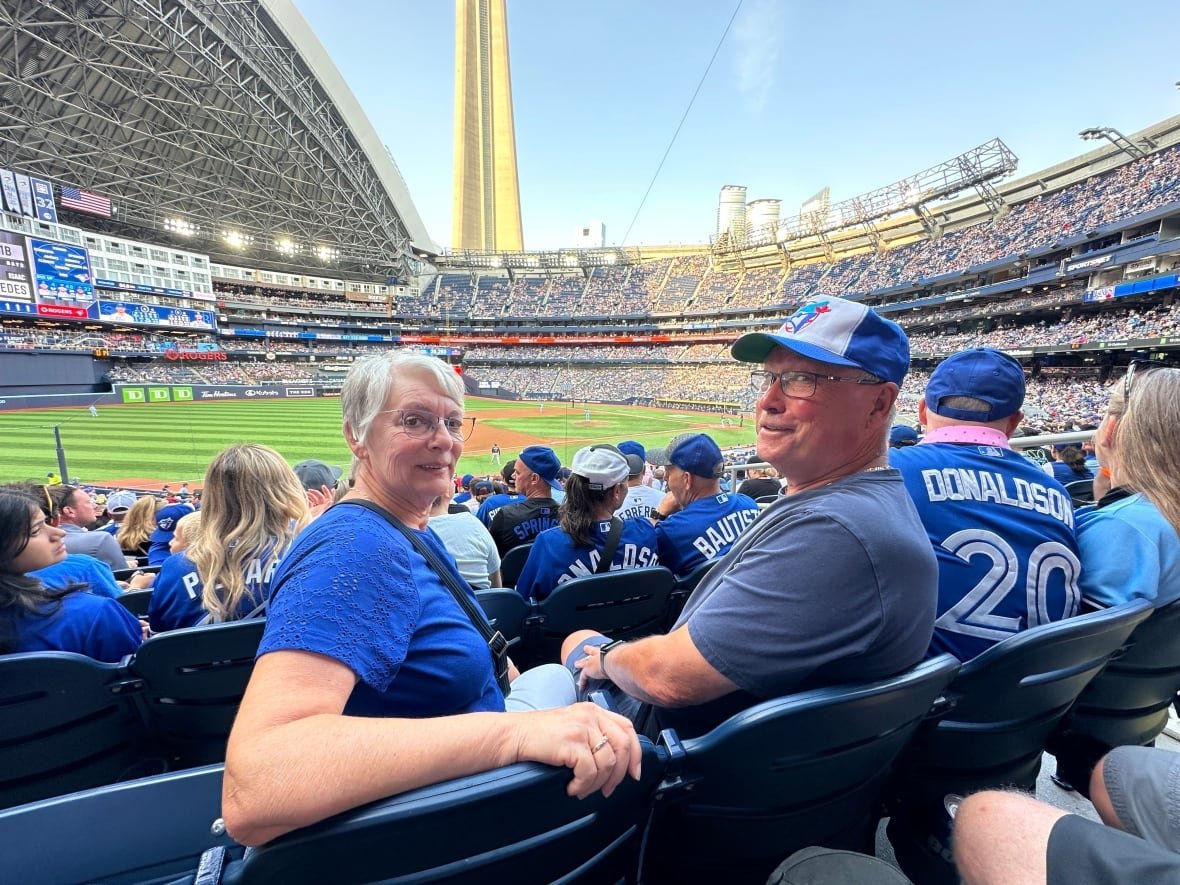 brenda-herback-1 Two seniors in blue at a sports game.