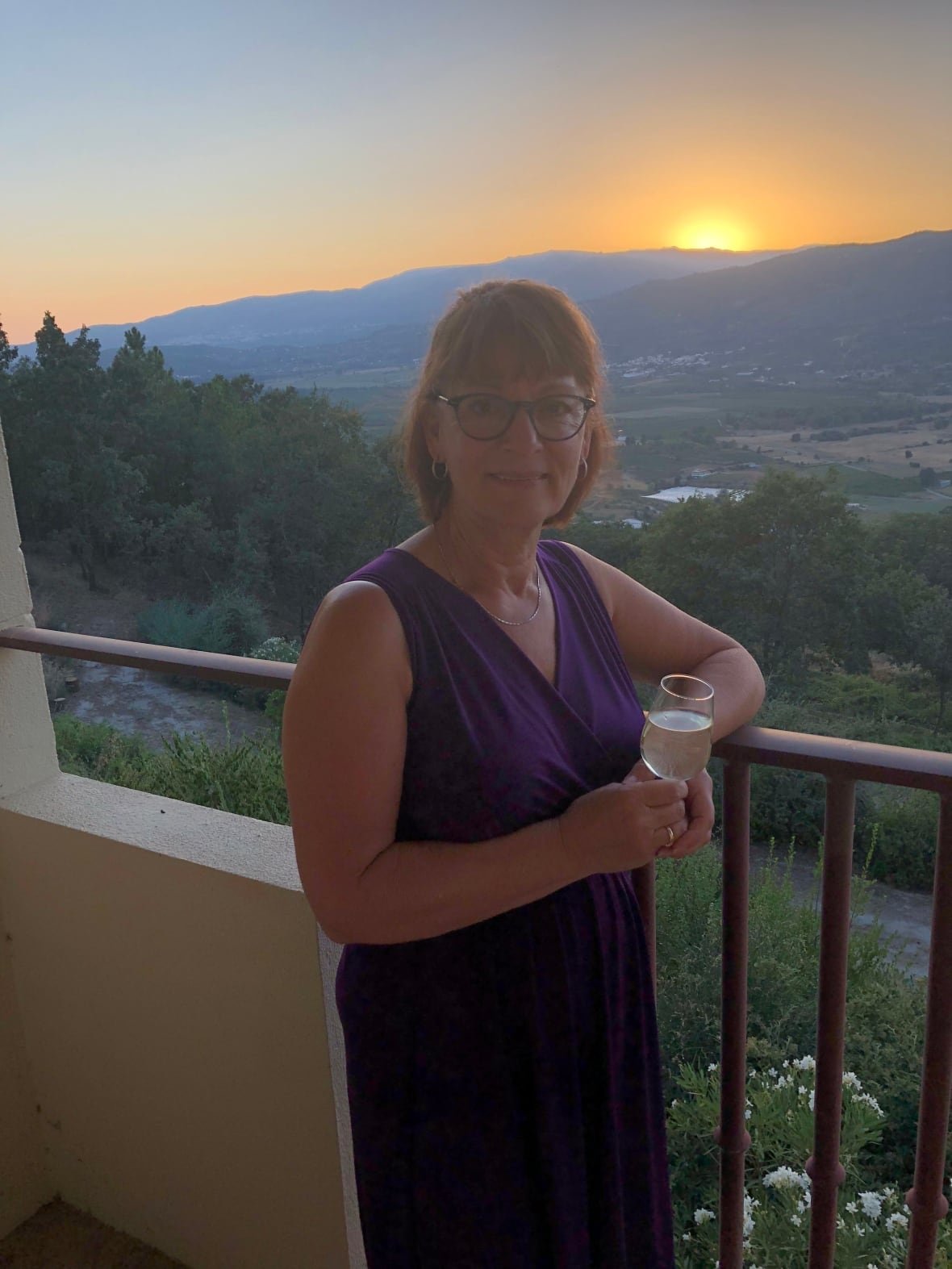brenda-herback-3 A woman in a purple dress with a glass of wine at sunset.