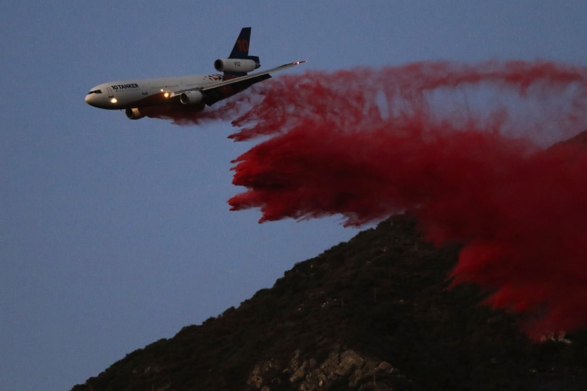 california-wildfires-41 An airplane drops a pink dusting over some hills