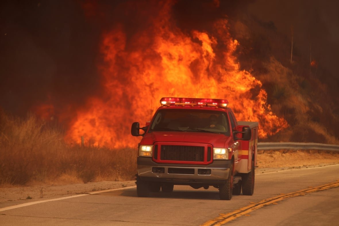 california-wildfires-50 A firetruck drives past flames.