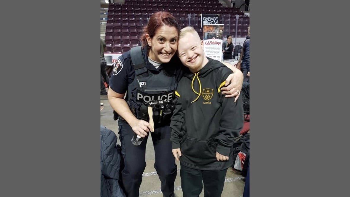 cealia-gagnon-and-austin-clapp A police officer smiles with an individual with Down Syndrome.