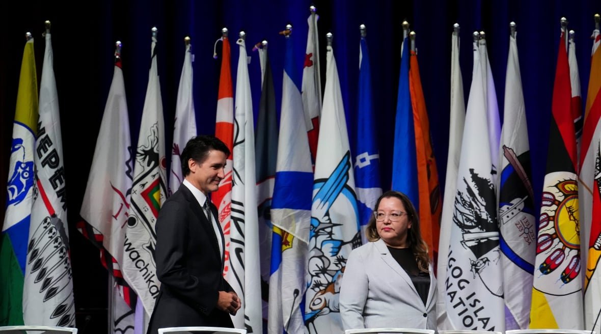 cindy-woodhouse-nepinak-justin-trudeau-2024-1 Two politicians walk to a table with microphones ahead of a panel discussion.