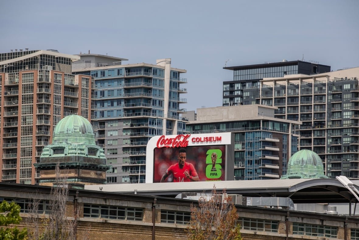fifa-world-cup-2026-official-brand-reveal A billboard showing FIFA's 2026 campaign amid condos and high-rises.