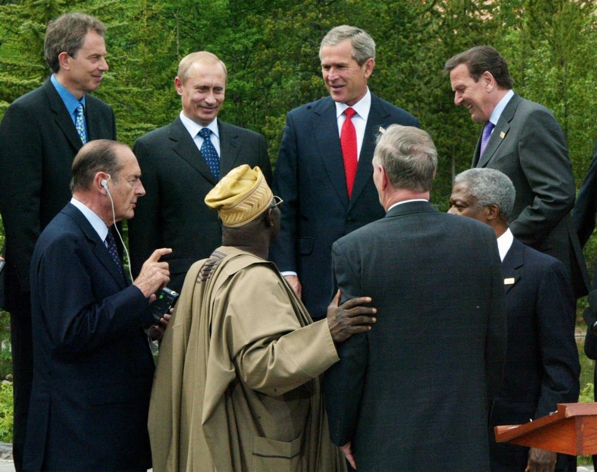 A group of men stand in a circle.