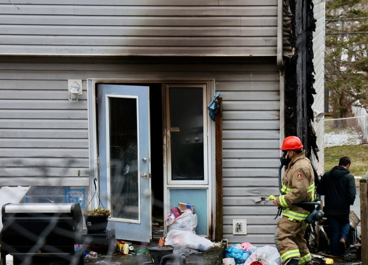 house-fire-lower-sackville-3 Firefighter outside of house damaged by fire