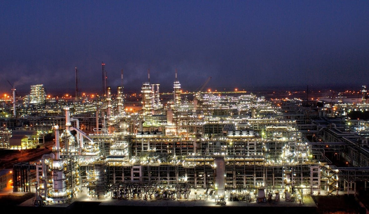 india-russia-oil A sprawling, brightly lit oil refinery is seen against the night sky.