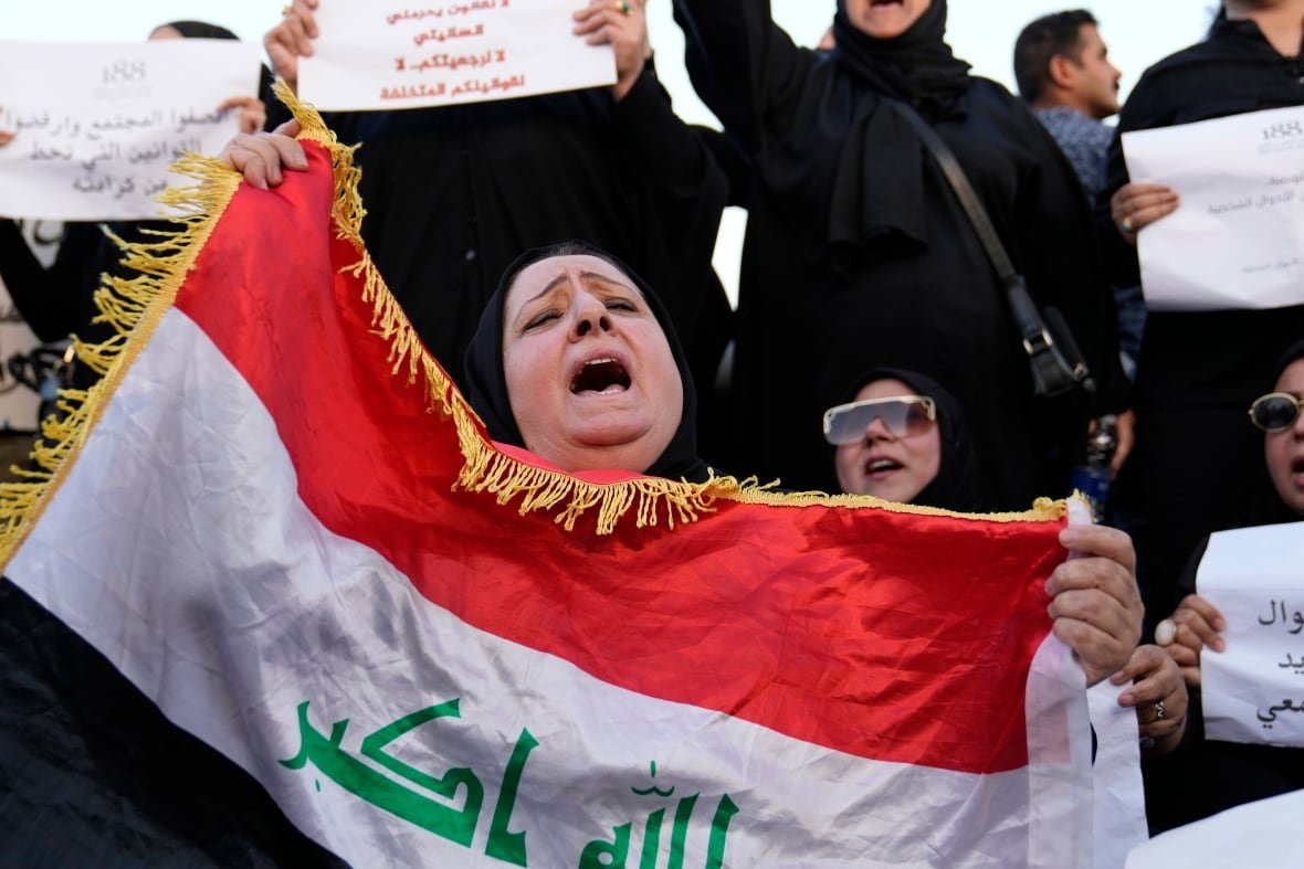 A woman holds a flag at a protest.