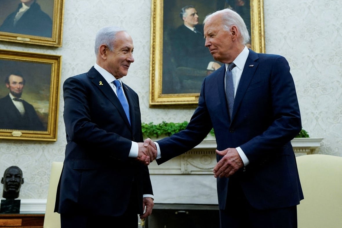 israel-palestinians-usa-sullivan-1 Two men in dark suits shake hands, smiling.
