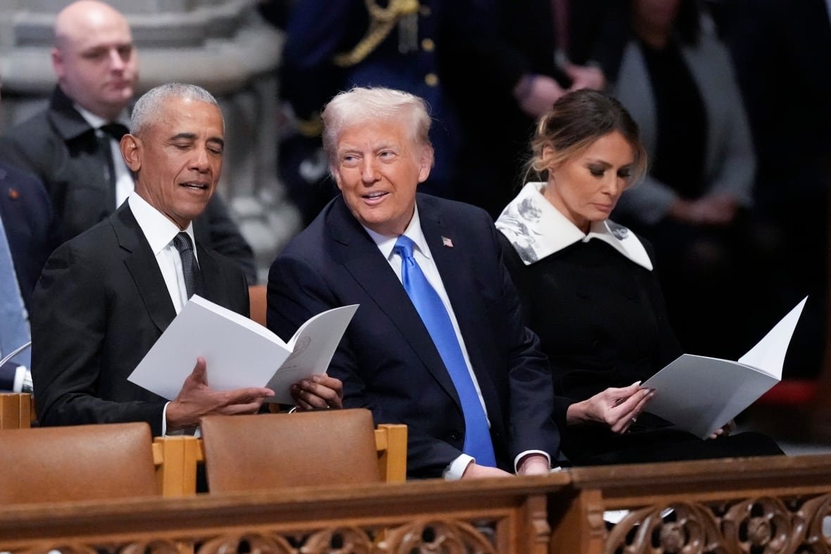 jimmy-carter-2 Two men, one Caucasian and one dark complected man are seated in suit and tie a church pew and appear to be in conversation. Beside the Caucasian man a Caucasian woman appears to be reading.