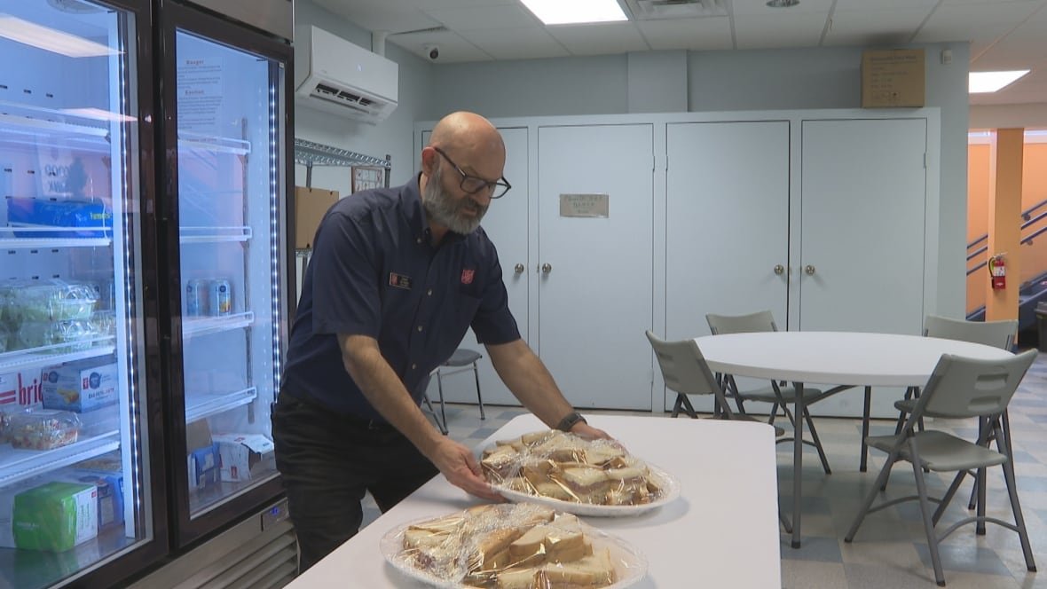 John Burton places a tray of sandwiches on a table.