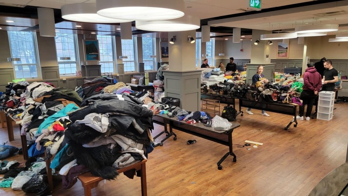mun-student-thrift-shop-1 Tables full of clothes in a large room with wooden flooring.