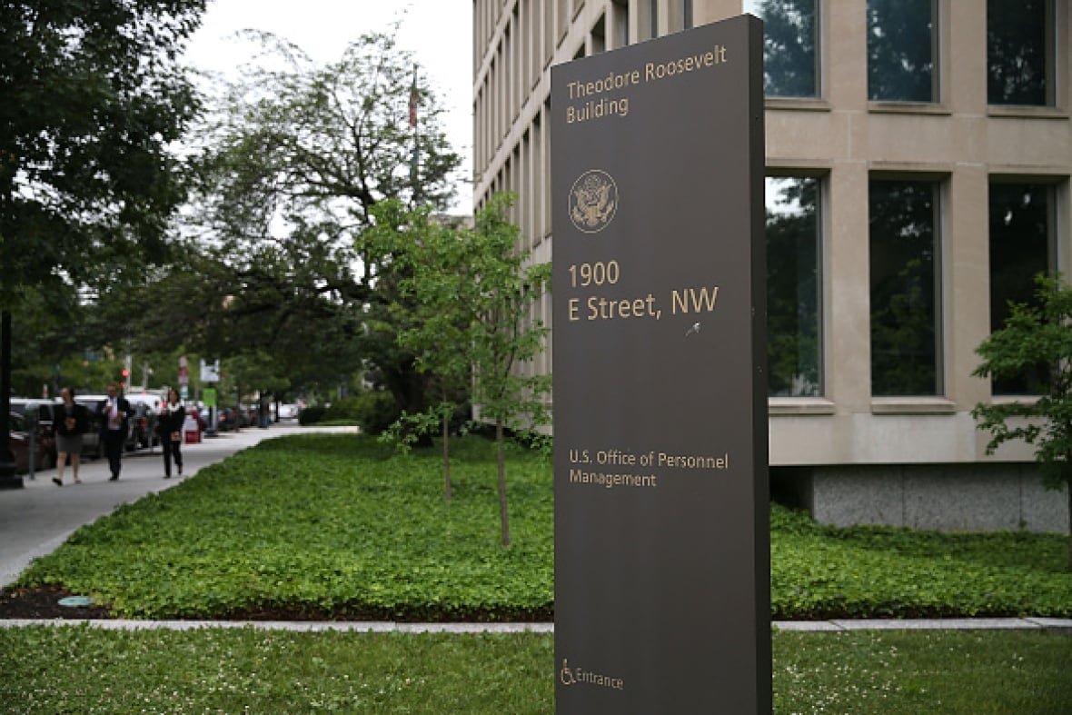 An office building is shown with a sign that says: U.S. Office of Personnel Management.