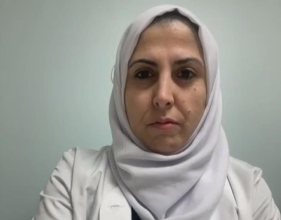 ola-alrayyes-ottawa-gaza-palestine-ceasefire-reaction A woman wearing a white hijab and blazer looks into the camera.