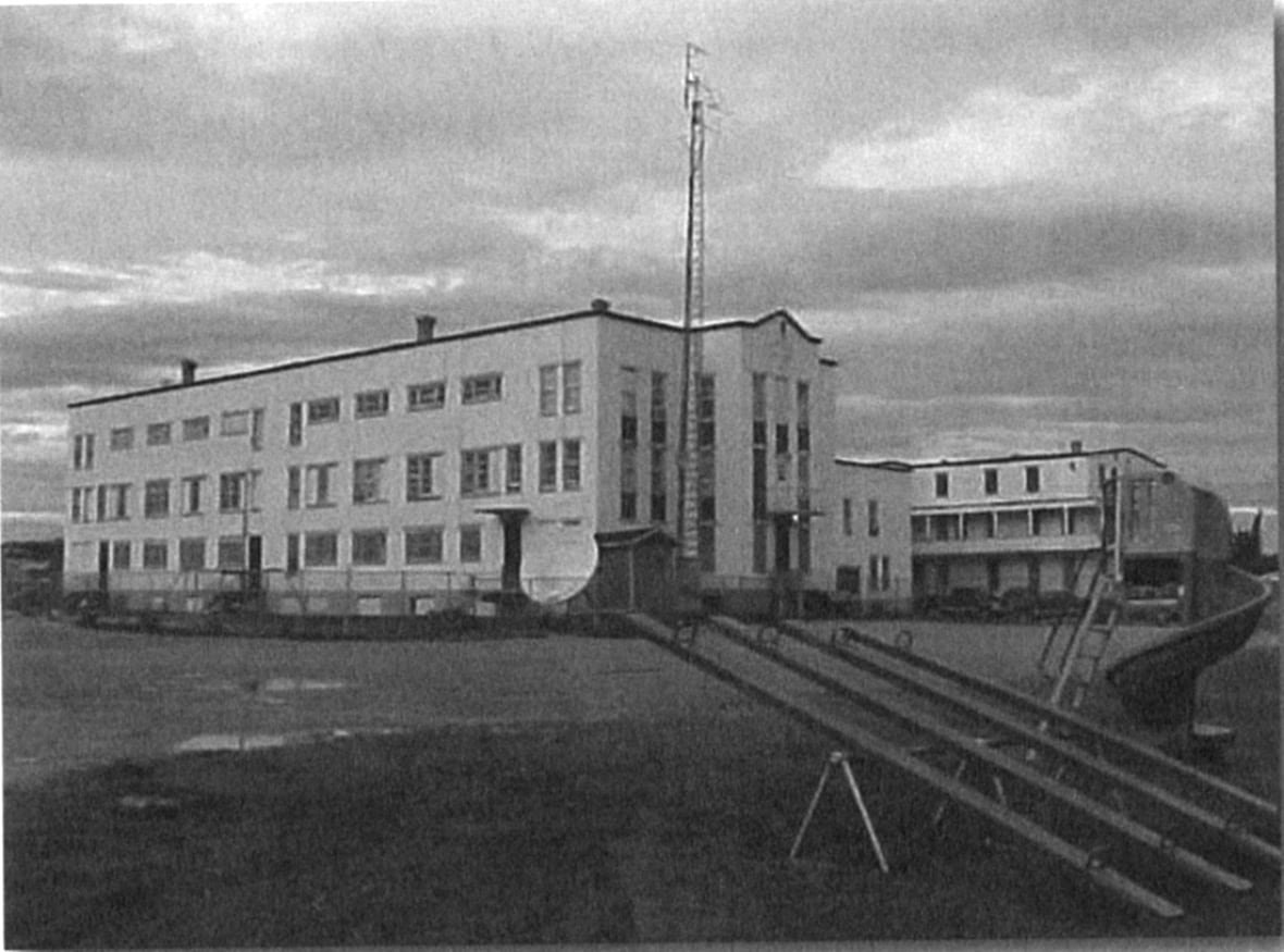 st-anne-s-residential-school-2 Black and white photo of a large imposing institutional building with swingsets in the foreground.