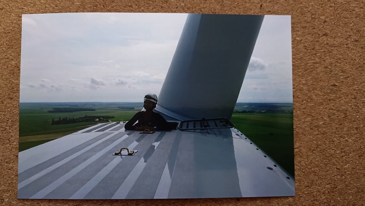 Tayssa Waldron standing in shadow of wind turbine blade.
