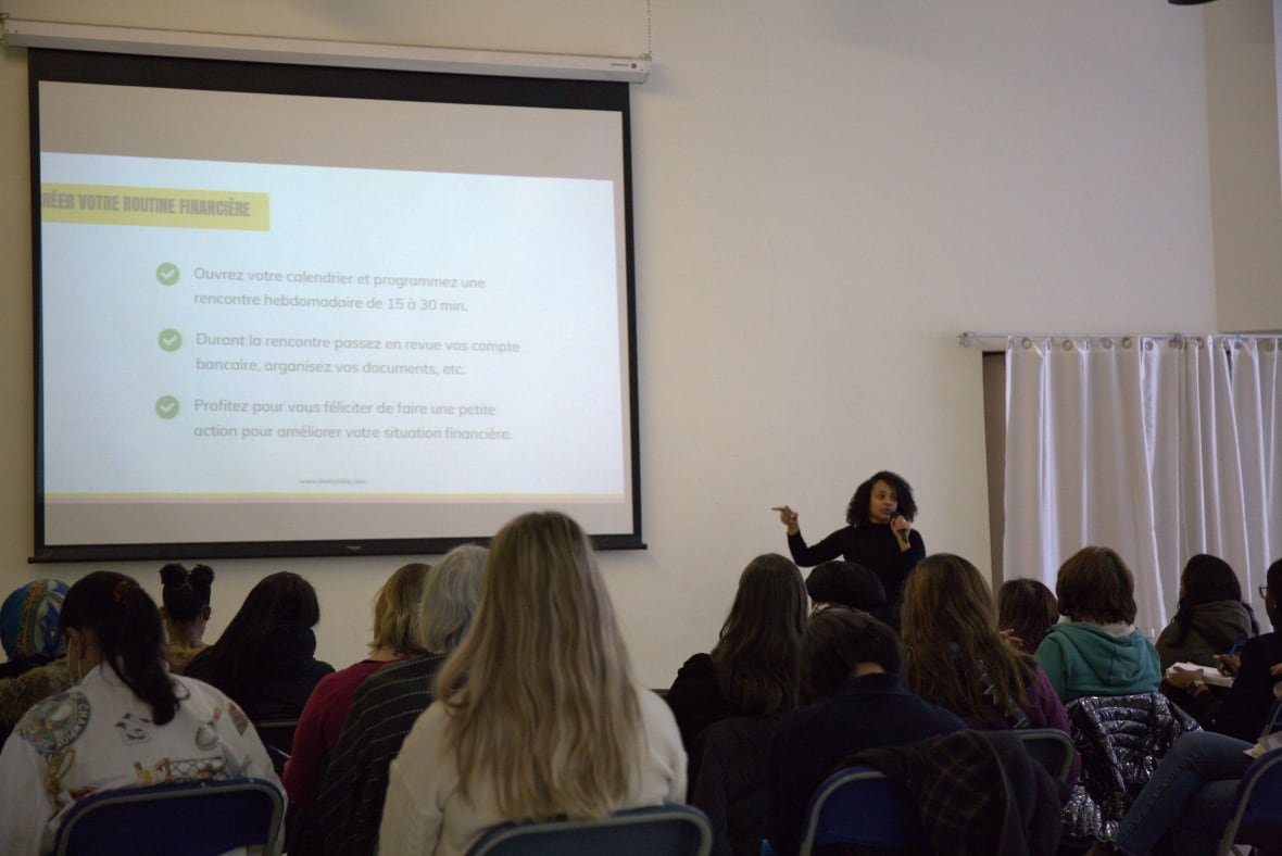 A woman gives a presentation in front of a group of people.