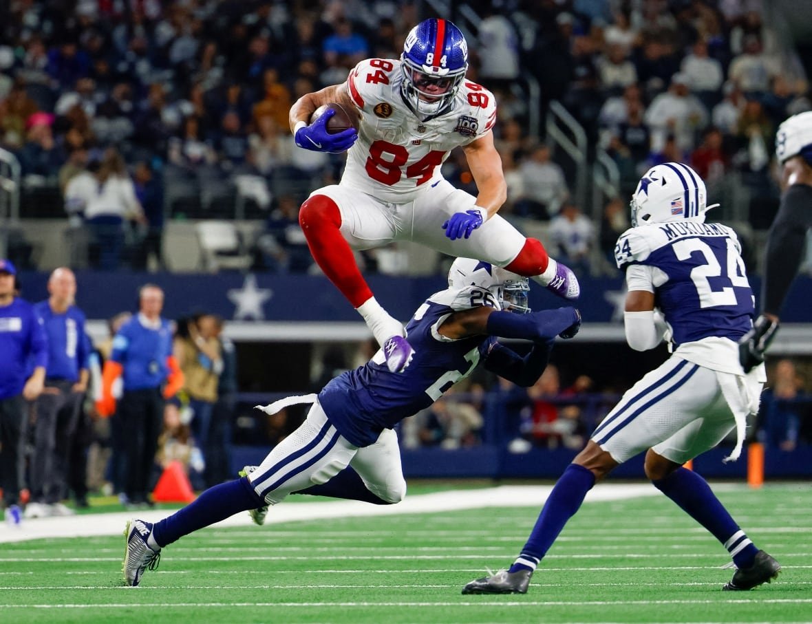 theo-johnson-1 New York Giants tight end Theo Johnson leaps over Dallas Cowboys cornerback DaRon Bland during the fourth quarter at AT&T Stadium.
