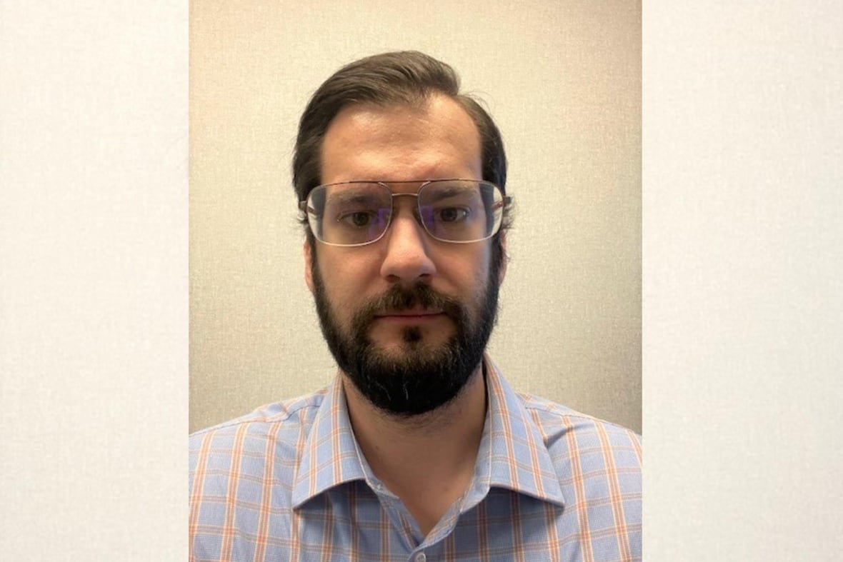 tom-power A man wearing glasses and a blue and orange checked shirt