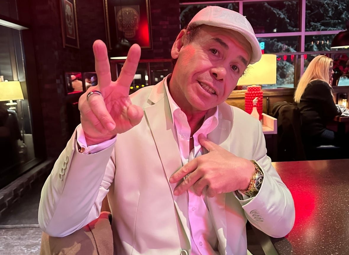 A man flashes a peace sign at a restaurant.