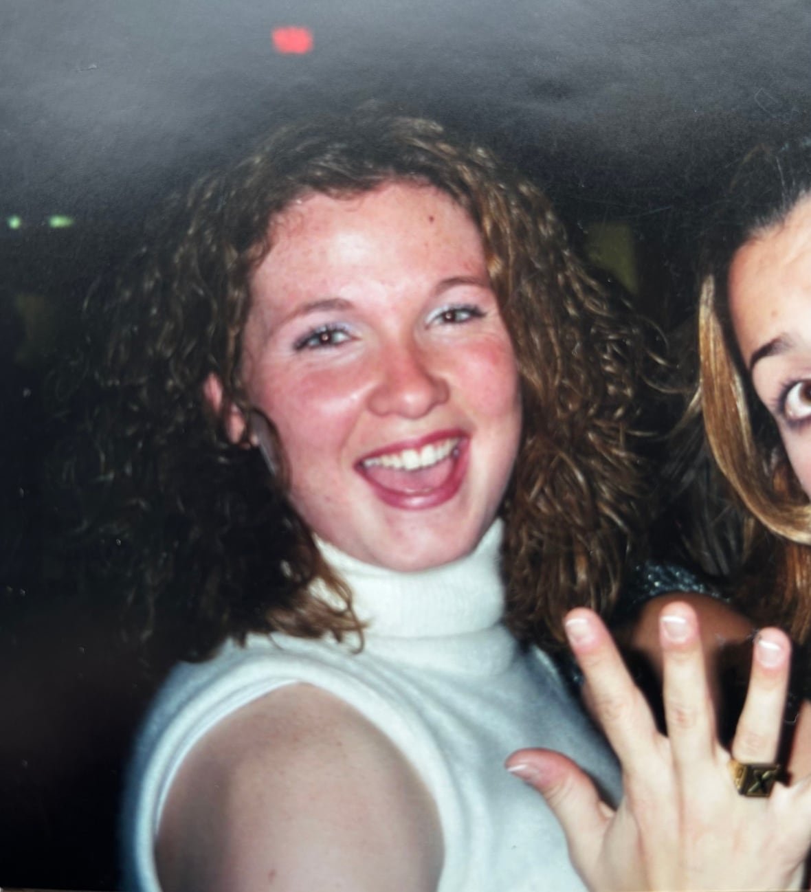 Woman smilling with a ring on her hand with an X.