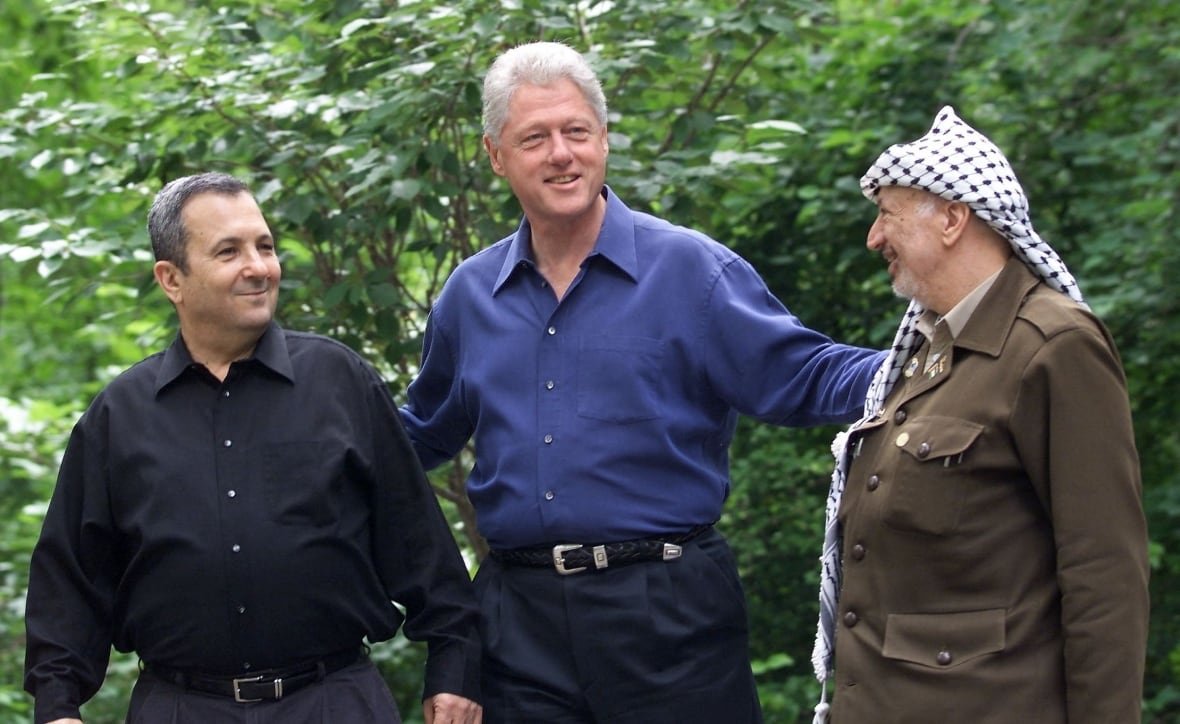 Israeli Prime Minister Ehud Barak (L), US President Bill Clinton (C), and Palestinian leader Yasser Arafat pause for a photo as they tour Laurel Cabin, the site where former Egyptian President Anwar Sadat, former Israeli Prime Minister Menachem Begin, and US President Jimmy Carter conducted peace talks in 1978, during the Middle East Peace Summit 11 July 2000 at Camp David, Maryland, the US presidential mountain top retreat. The peace talks are aimed at resolving the issues of the 52-year-old Israeli-Palestinian conflict including the status of Jerusalem, the borders and nature of a Palestinian state, and the future of Jewish settlers and Palestinian refugees.