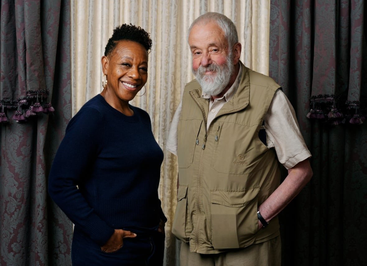 2024-tiff-hard-truths-portrait-session A woman and older man smile at the camera.