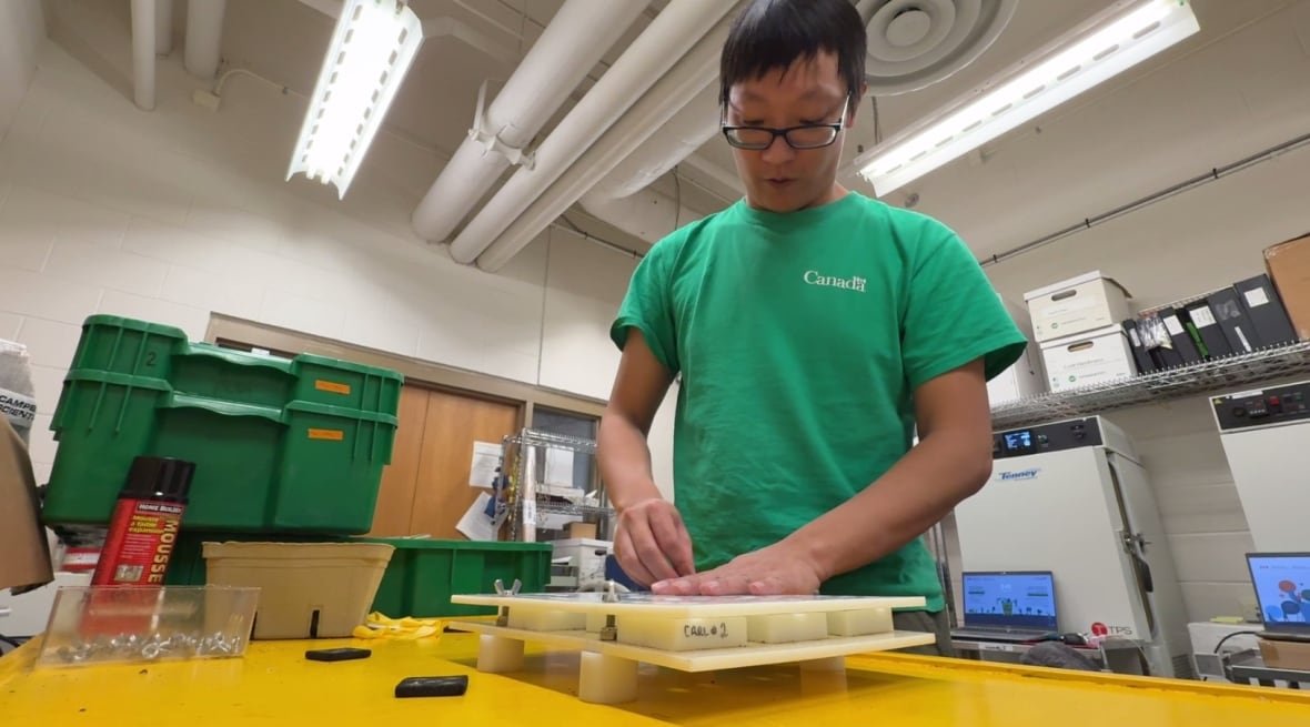 ben-min-chang Researcher Ben Min Chang with a tray full of vine samples. He's standing in a lab.