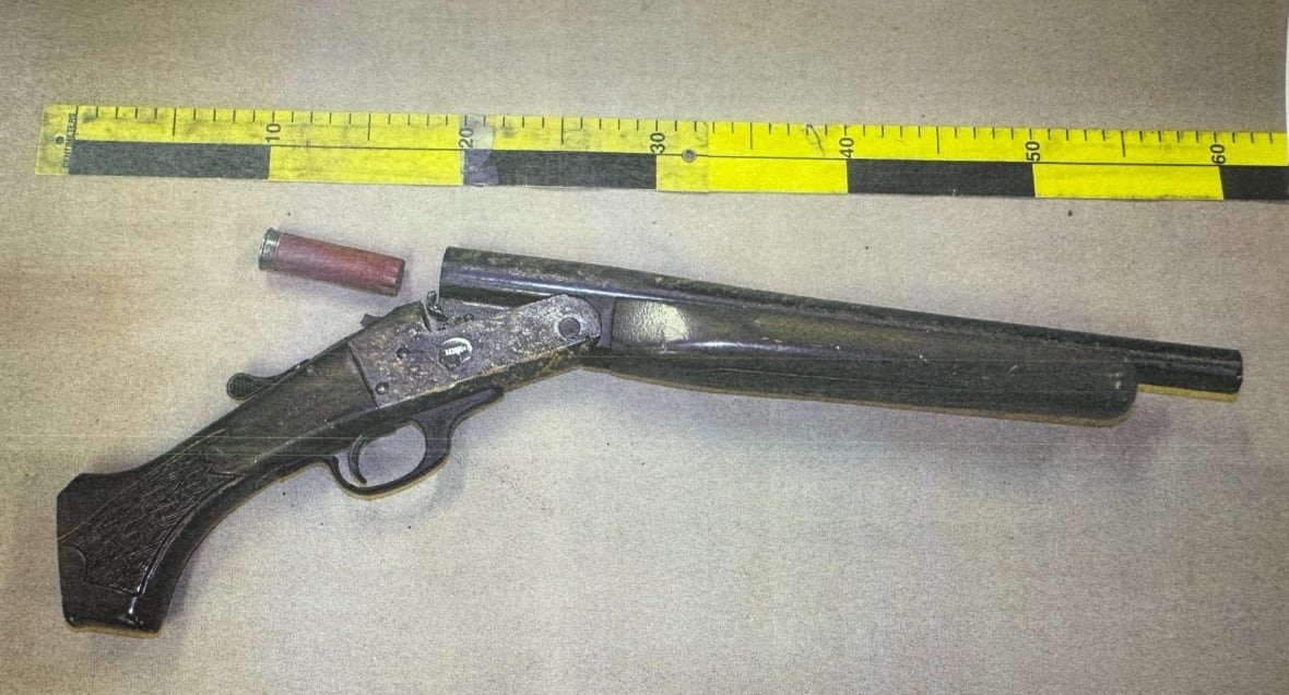 firearm-in-zakkary-reed-trial-2 A firearm and a shell casing on a table with a measuring tape beside them.