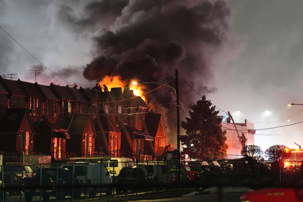 first-responders-deal-with-flames-smoke-after-plane-crash-in-philadelphia Fire and smoke are seen rising behind homes in Philadelphia following a plane crash.
