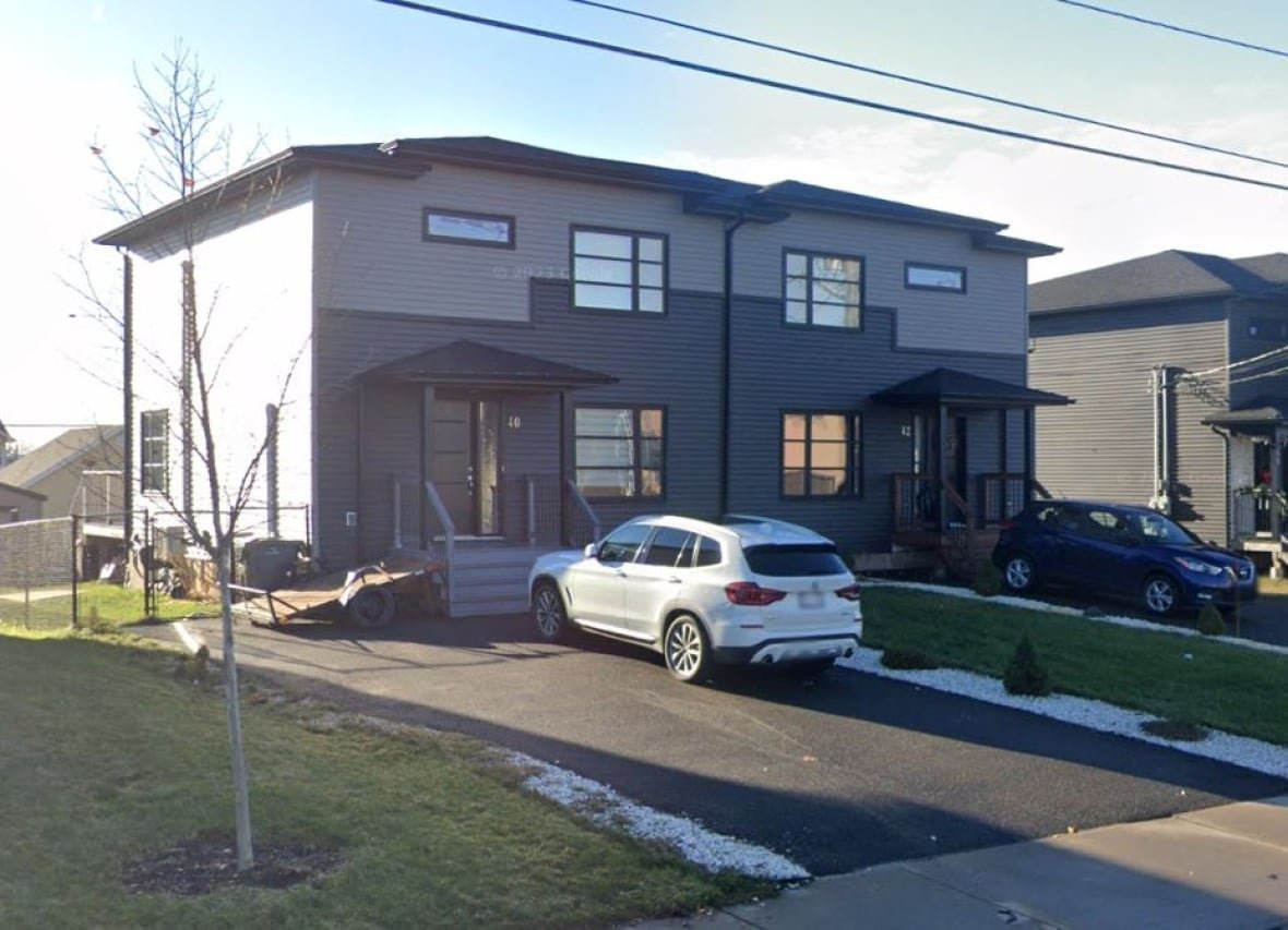 francfort-crescent-moncton A brown and beigh duplex house has a small white car sitting out front in the driveway.