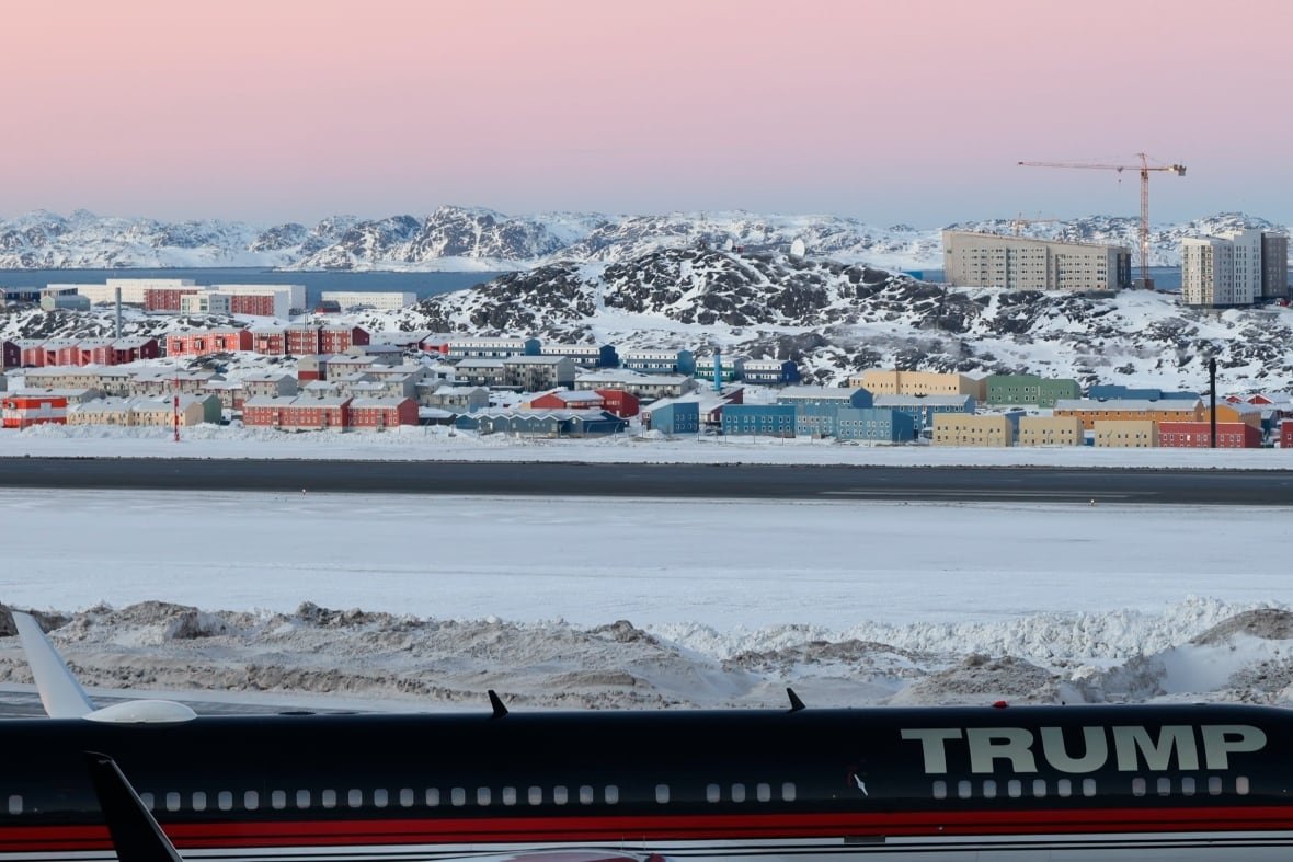 greenland-visit-trump-jr An airplane with the name TRUMP is seen landing on a wintery landscape.