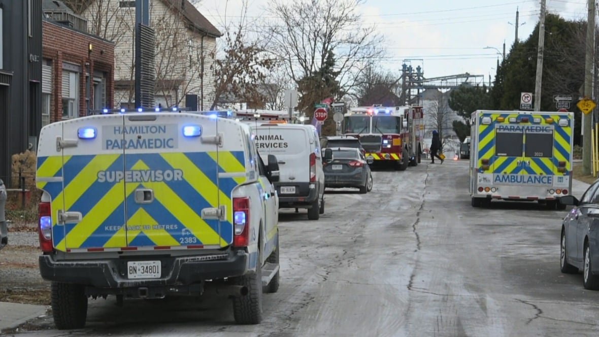 A street with several ambulances and a fire truck parked on it.