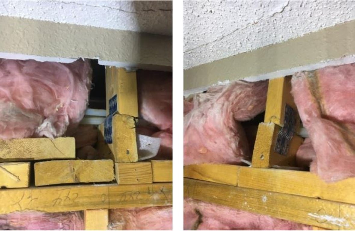 Wooden beams surrounded by pink insulation.