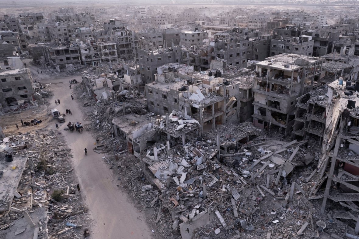 An aerial photograph taken by a drone shows Palestinians walking through the destruction.