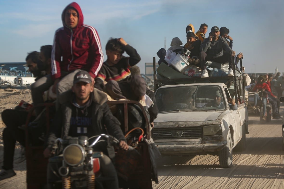 Displaced Palestinians travel on vehicles and motorcycles.
