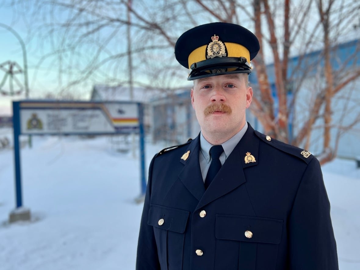 An RCMP officer stands in front of the RCMP detachment.