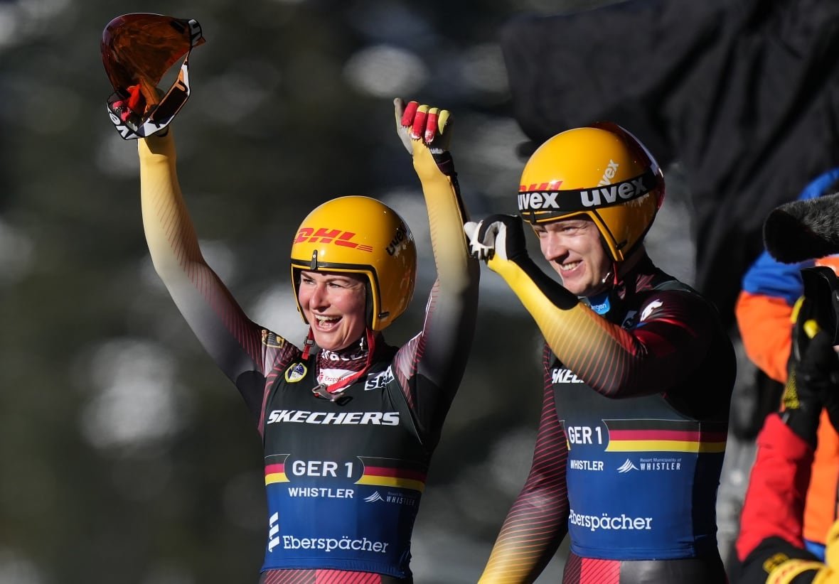 julia-taubitz-and-max-langenhan A male and a female luge athlete celebrates after winning a mixed event.