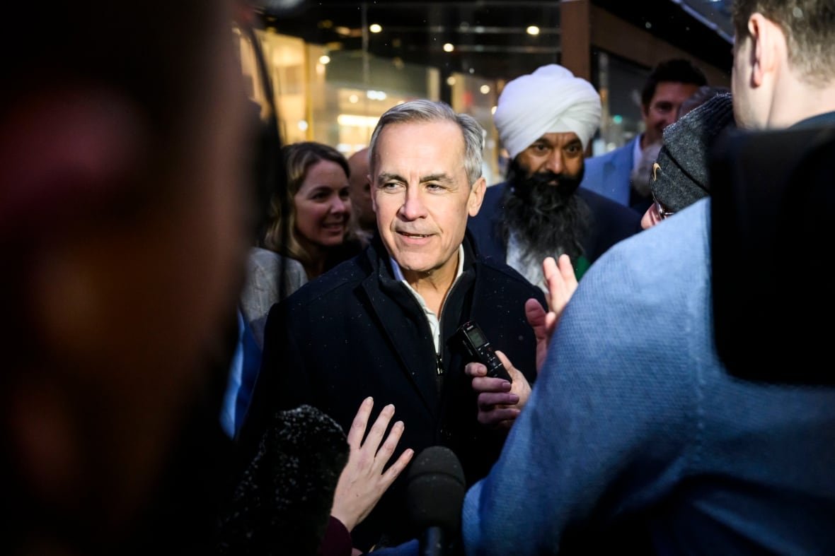 liberal-leadership-mark-carney-20250123 Mark Carney surrounded by microphones in Ottawa.