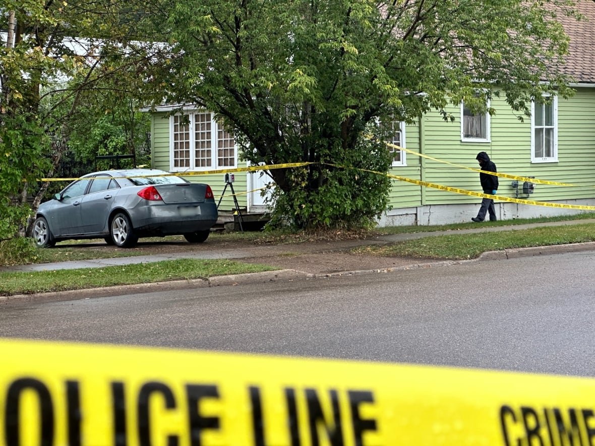 lloyd-deaths-rcmp A small green bungalow surrounded by yellow police tape.