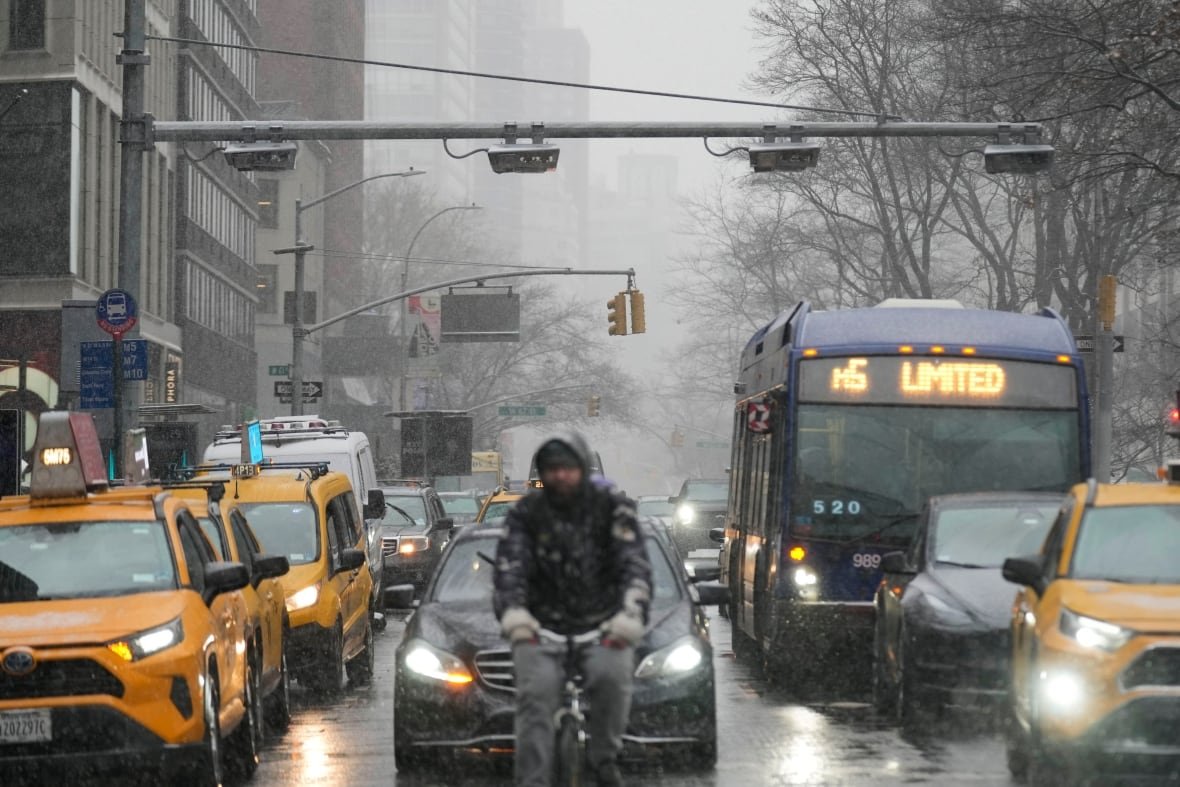 Devices used for congestion tolling hang above traffic on a Manhattan street in New York City.