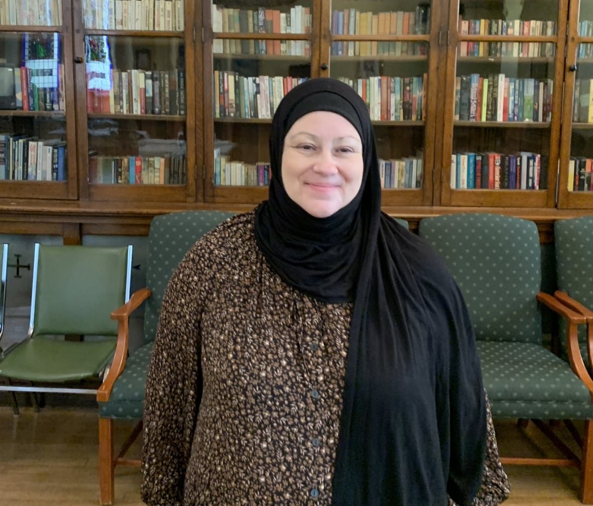 paula-radwan Woman wearing hijab with back to bookcase.