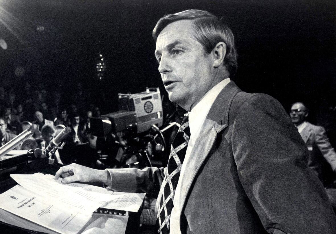 peter-lougheed Black-and-white 1970s photo of a suited politician, talking at a lectern.