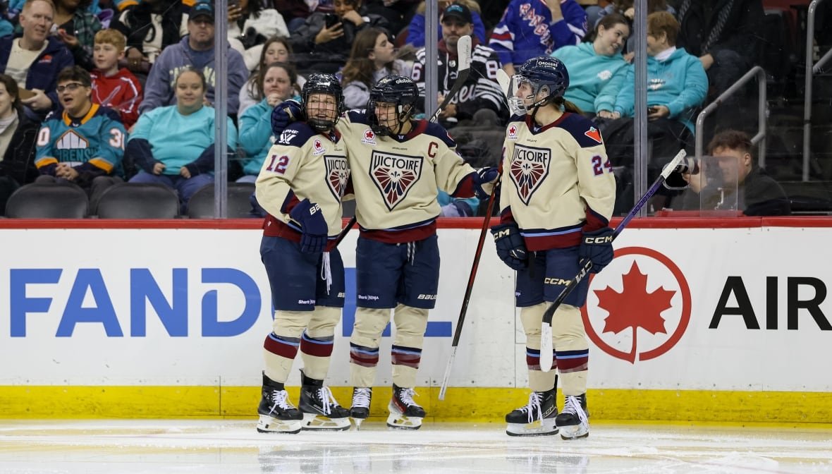 pwhl-sirens-regular-season Three hockey players wearing Montreal Victoire cream-coloured jerseys celebrate on the ice.
