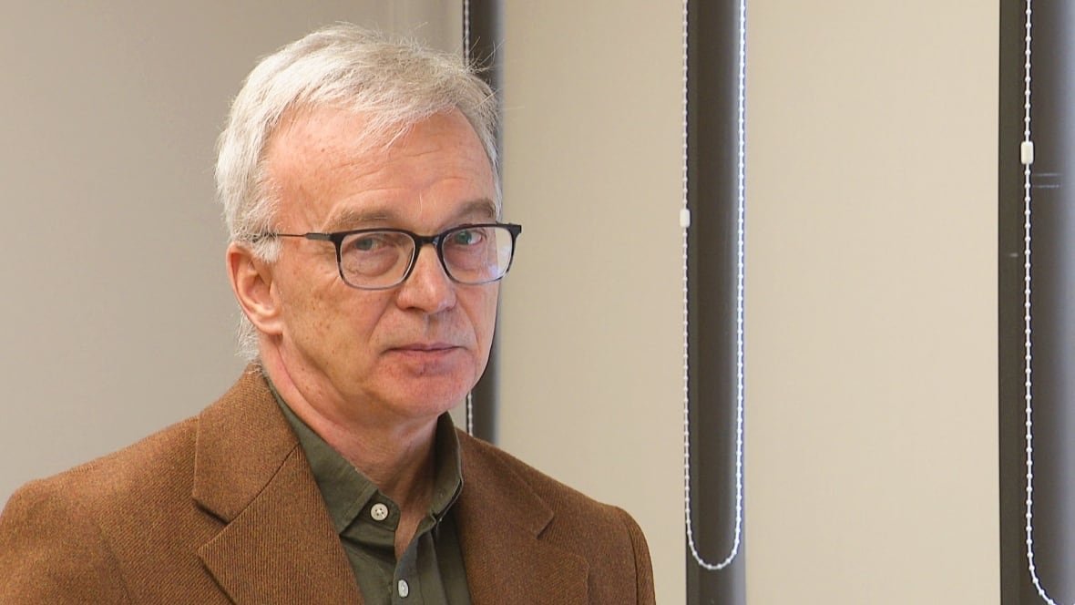 sean-casey Man with brown jacket and grey hair.