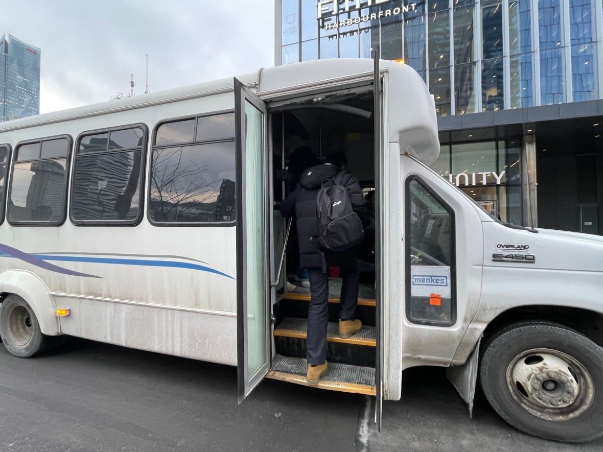 Man stepping on to a shuttle bus.