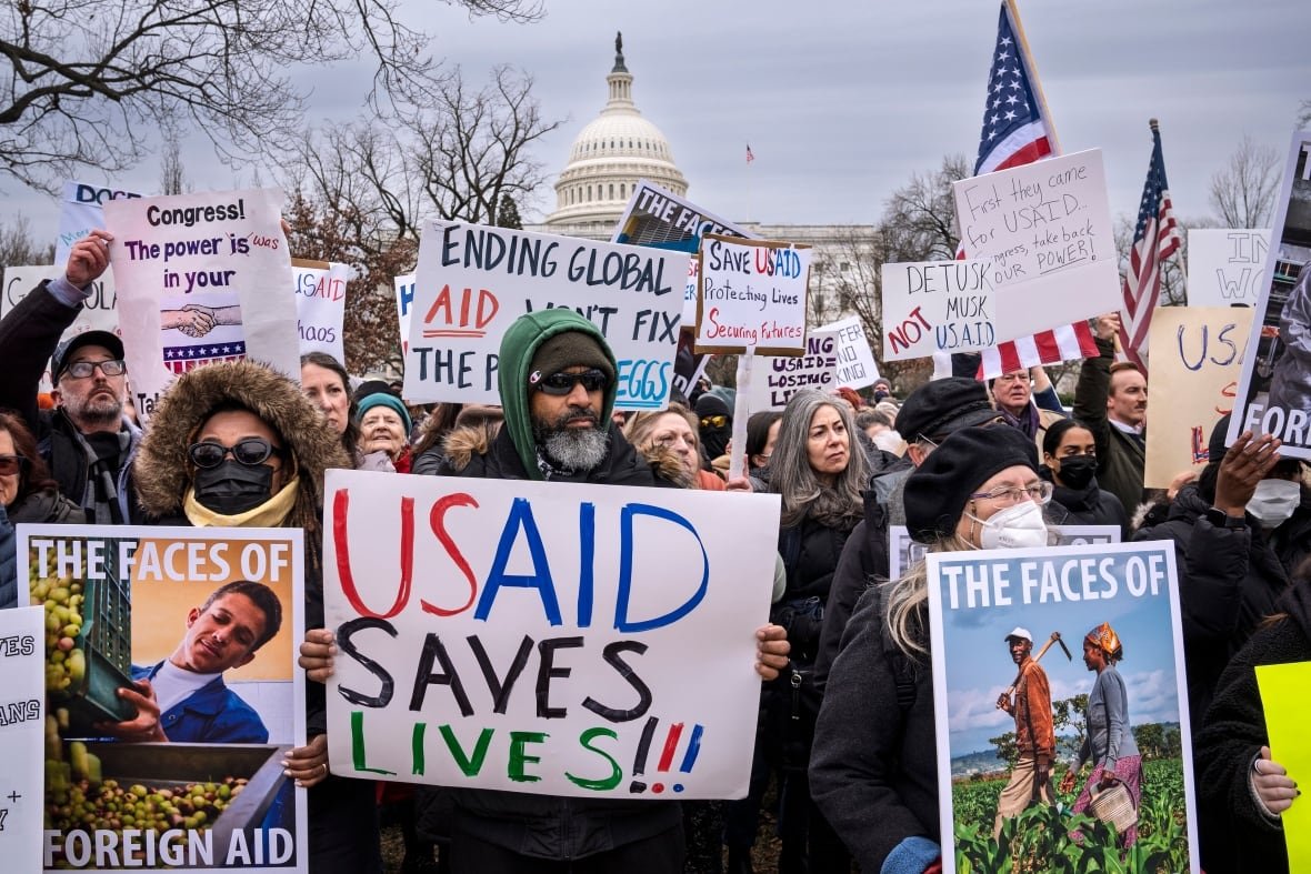 Protesters hold signs outside of the White House.