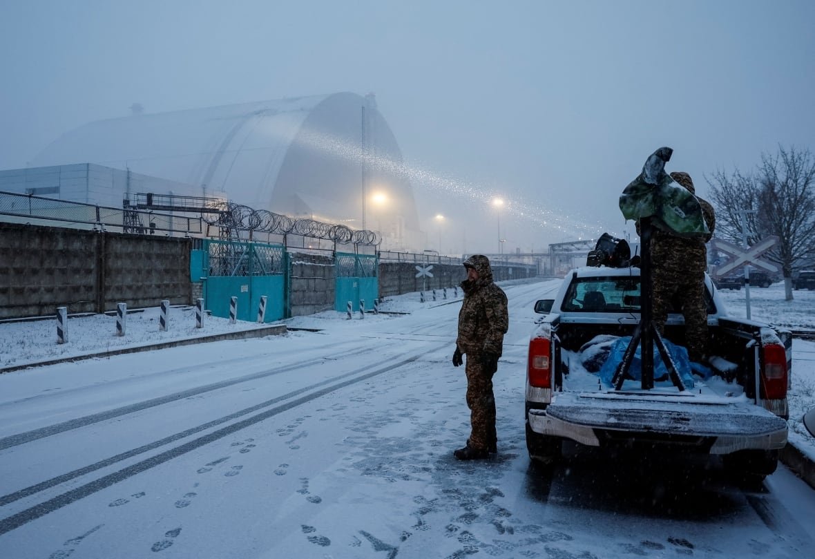 ukraine-crisis-attack-chornobyl-1 Ukrainian servicemen use a searchlight as rescuers work at the New Safe Confinement (NSC) structure, that covers the old sarcophagus which confines the remains of the damaged fourth reactor.