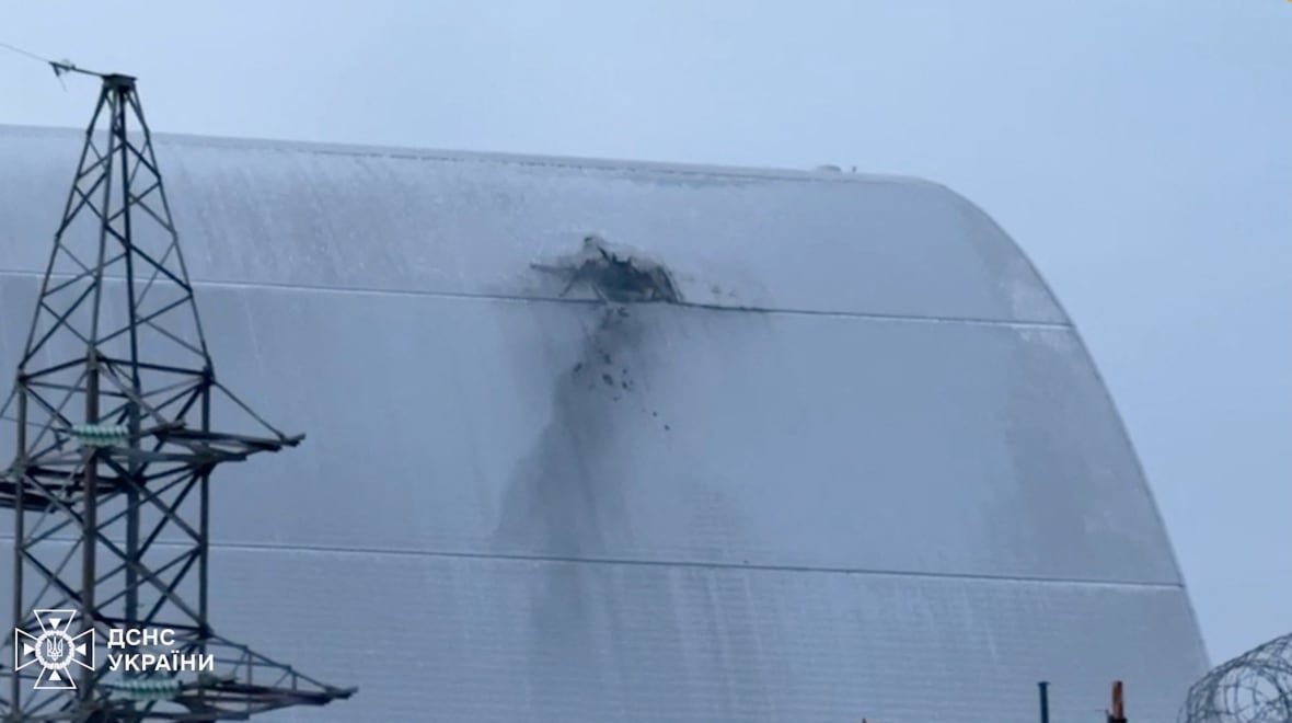 ukraine-crisis-attack-chornobyl-2 A damaged section of a white roof of a structure is shown outdoors.