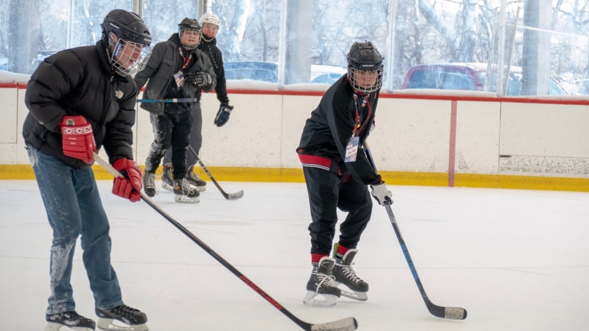 winnipeg-aboriginal-sport-achievement-centre-youth-1 Four youth skate on a rink while playing hockey.
